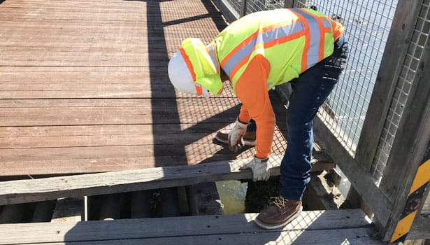Construction worker replacing pathway deck board